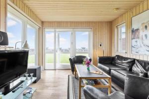 a living room with leather furniture and a large window at FY295-Faaborg-Mosegarden-39 in Faaborg