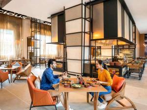 two people sitting at a table in a restaurant at ibis Mumbai Vikhroli - An Accor Brand in Mumbai