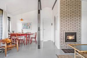 a dining room with a table and chairs and a fireplace at FY184-Asperup-Eskelundsvej-21 in Asperup +13 photos