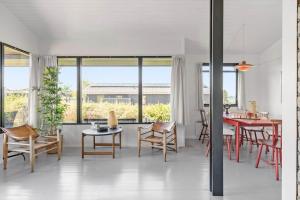 a living room with tables and chairs and windows at FY184-Asperup-Eskelundsvej-21 in Asperup