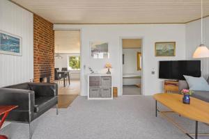 a living room with a couch and a tv at FY155-Middelfart-Daemningen-99 in Middelfart