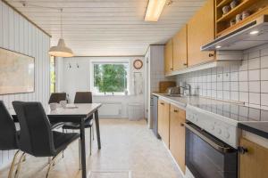 a kitchen with a table and a dining room at FY155-Middelfart-Daemningen-99 in Middelfart