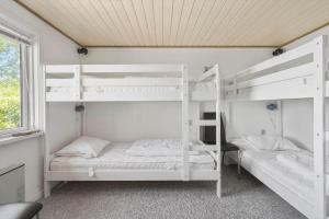 two white bunk beds in a room with a window at FY155-Middelfart-Daemningen-99 in Middelfart
