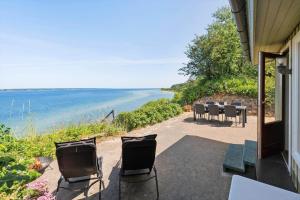 a patio with chairs and a view of the ocean at FY155-Middelfart-Daemningen-99 in Middelfart