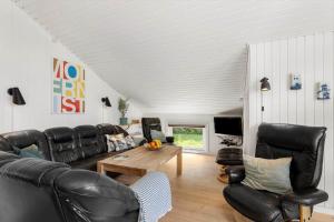 a living room with black leather furniture and a table at FY386-Hesselager-Stentoften-22 in Hesselager