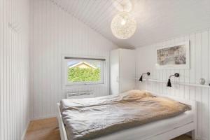 a white bedroom with a bed and a window at FY386-Hesselager-Stentoften-22 in Hesselager