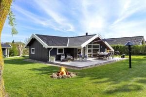 a house with a fire pit in the yard at FY386-Hesselager-Stentoften-22 in Hesselager