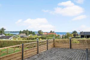 a wooden fence with a walkway in front of a house at FY403-Asperup-Eskelundsvaenget-1 in Båring +17 photos