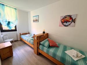 a bedroom with two twin beds and a table at Prati Escape - Apartment with Pool and Lakeview in Lierna +16 photos