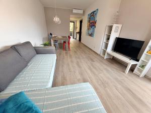a living room with a couch and a flat screen tv at Prati Escape - Apartment with Pool and Lakeview in Lierna