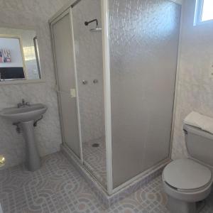 a bathroom with a shower and a toilet and a sink at Hotel Catalina in Torreón +7 photos