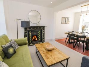 a living room with a green couch and a fireplace at Ty Mawr Farm in Llanfairpwllgwyngyll