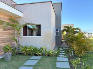 a garden with a stone walkway in front of a house at Chalé de Luxo com Piscina em Barra dos Coqueiros, Sergipe in Barra dos Coqueiros