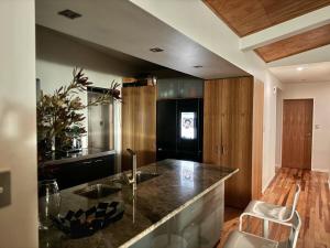 a kitchen with a counter and a black refrigerator at Raumati Sunsets in Raumati Beach +16 photos