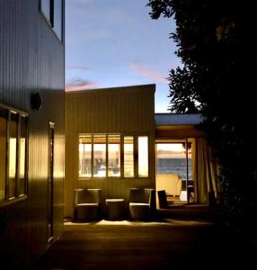 a house with a porch with chairs and windows at Raumati Sunsets in Raumati Beach