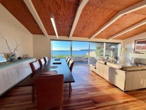 a dining room with a table and a couch at Raumati Sunsets in Raumati Beach