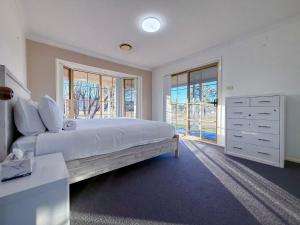 a bedroom with a large bed with a dresser and windows at Marrangaroo Meadows in Marrangaroo +155 photos