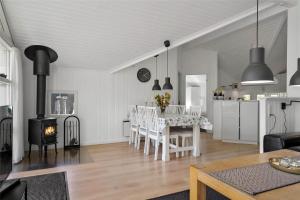 a kitchen and a living room with a table and a fireplace at C11221-Hemmet-Egernvej-2 in Hemmet
