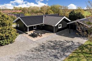 a black house with a bench in a yard at C11221-Hemmet-Egernvej-2 in Hemmet