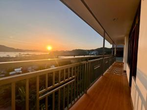 a balcony with a view of the ocean at sunset at OHANA Homestay in Coron