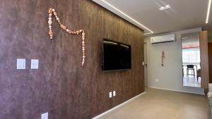 a living room with a wall with a flat screen tv at High Standard Two Bedroom Apartment Private Pool Frances Beach Garden 209 in Marechal Deodoro