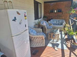 a refrigerator on a patio with chairs and a couch at Moto GP Hidden Gem in Coronet Bay