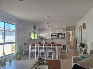 a kitchen and living room with a table and chairs at Moto GP Hidden Gem in Coronet Bay