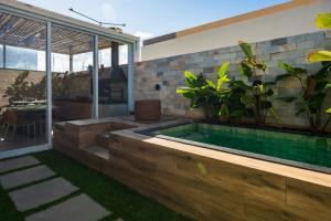a swimming pool in a house with a patio at Chalé de Luxo com Piscina em Barra dos Coqueiros, Sergipe in Barra dos Coqueiros