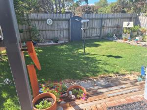 a yard with a fence and some potted plants at Moto GP Hidden Gem in Coronet Bay