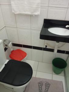a bathroom with a black toilet and a sink at FLAT PERTO do centro de convenções e Chevrolet Hall in Recife +7 photos