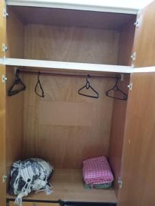 a wooden cabinet with two hangers in a closet at FLAT PERTO do centro de convenções e Chevrolet Hall in Recife