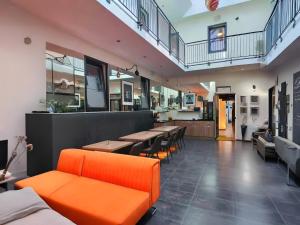 a restaurant with orange furniture and tables and chairs at Dancenter Hotel Jomfru Ane Standard Double in Aalborg