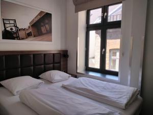 a bed in a bedroom with a window at Dancenter Hotel Jomfru Ane Standard Double in Aalborg