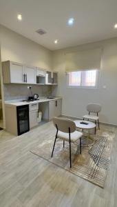 eine Küche mit zwei Stühlen und einem Tisch in einem Zimmer in der Unterkunft Alturya in Al-'Ula