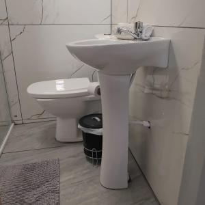 a bathroom with a white sink and a toilet at Small and cozy in Ijuí +7 photos