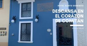 a blue house with a door and a sign at Hotel Santo Domingo in Comitán