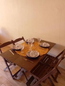 a wooden table with plates and glasses on it at Hospedaria Café Terra&Sabor in Palmeiras