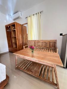 a wooden bench in a room with flowers on it at Sunset Rote Bungalows in Nembrala