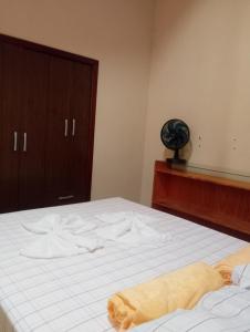 a bedroom with a bed with a towel on it at Hospedaria Café Terra&Sabor in Palmeiras