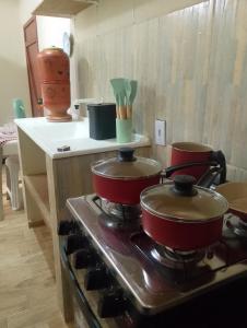 two pots and pans on a stove in a kitchen at Hospedaria Café Terra&Sabor in Palmeiras