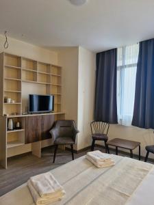 a hotel room with a bed and a tv at Nike aghmashenebeli str 158 in Kobuleti