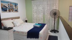 a bedroom with a bed and a fan in it at Hospedagem da Lu in Paraty