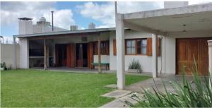 a house with a green lawn in front of it at Casa Quinta Malu in Gualeguaychú