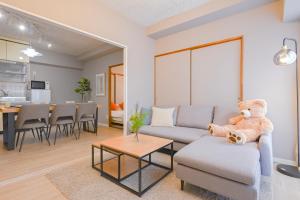 a teddy bear sitting on a couch in a living room at 弥富民泊 - Yatomi Minpaku - in Yatomi 