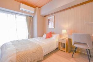 a bedroom with a bed and a desk and a chair at 弥富民泊 - Yatomi Minpaku - in Yatomi 