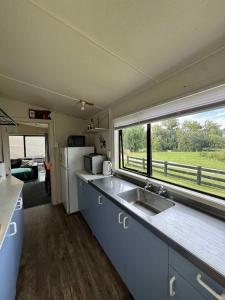 an rv kitchen with a sink and a window at Lime Ridge Farm Cottage in Fairlie
