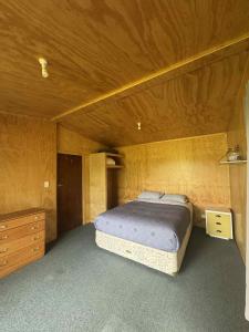a bedroom with a bed and a wooden ceiling at Lime Ridge Farm Cottage in Fairlie