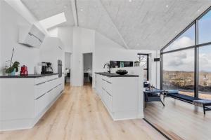 a kitchen with white cabinets and a large window at 8912-Allingabro-Fyrrevej-6 in Allingåbro