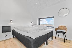 a bedroom with a bed and a chair and a tv at 8912-Allingabro-Fyrrevej-6 in Allingåbro