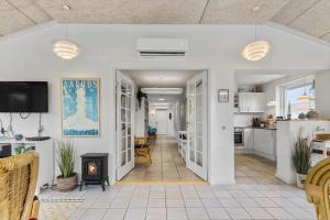 a living room with a fireplace and a kitchen at 8592-Glesborg-Muslingevej-9 in Glesborg
